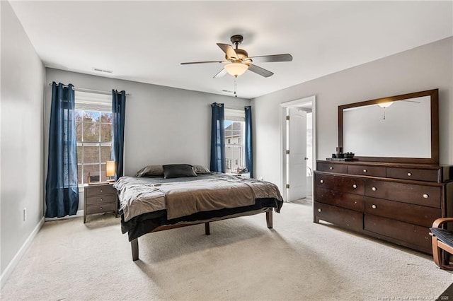 bedroom featuring visible vents, baseboards, light colored carpet, and a ceiling fan