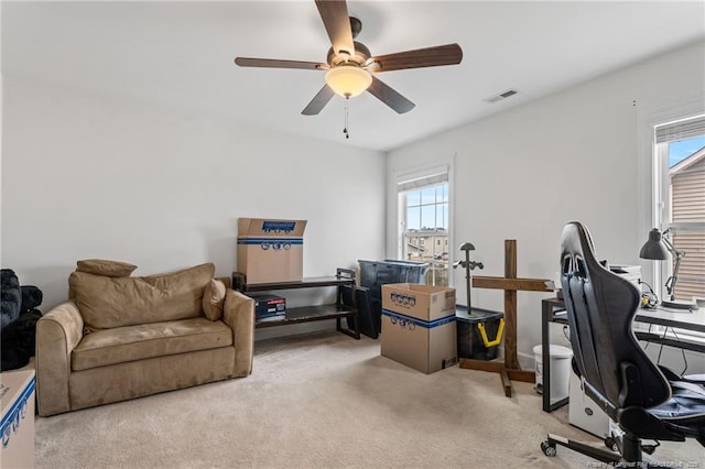 office area with visible vents, light carpet, and a ceiling fan