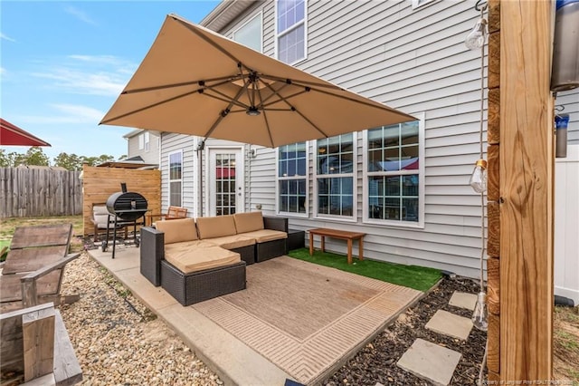 view of patio with an outdoor living space, a grill, and fence