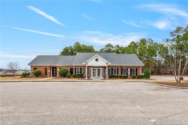 greek revival inspired property featuring french doors and brick siding