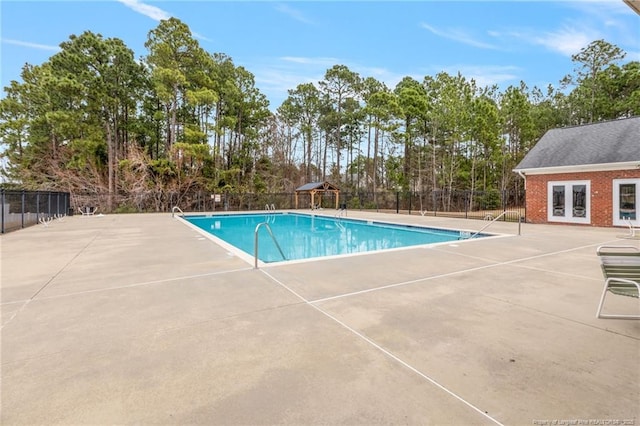 community pool with a patio area, french doors, and fence