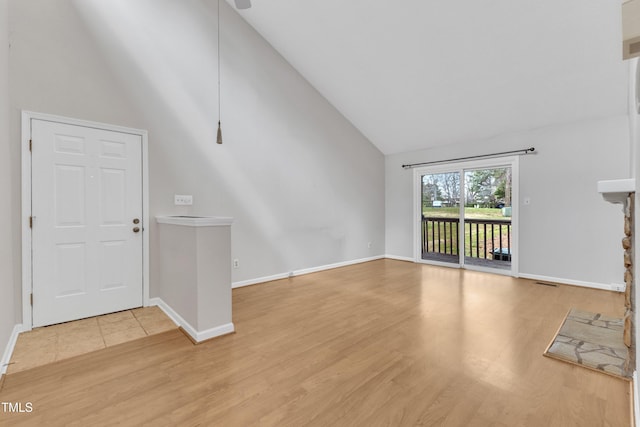 unfurnished living room featuring visible vents, high vaulted ceiling, baseboards, and wood finished floors