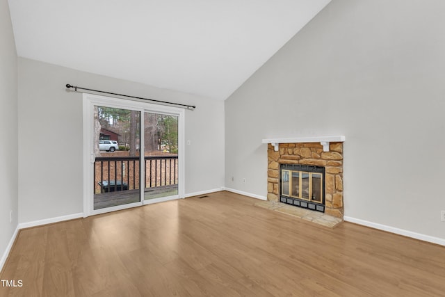 unfurnished living room featuring a fireplace, wood finished floors, baseboards, and high vaulted ceiling