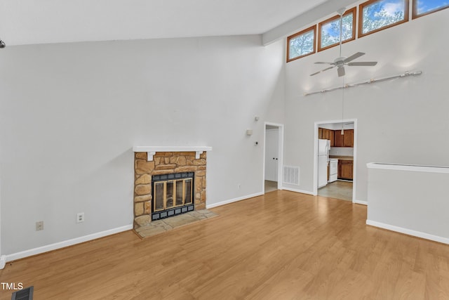 unfurnished living room featuring visible vents, a fireplace, ceiling fan, and wood finished floors