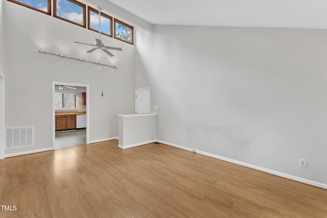 unfurnished living room featuring a wealth of natural light, visible vents, baseboards, and light wood finished floors