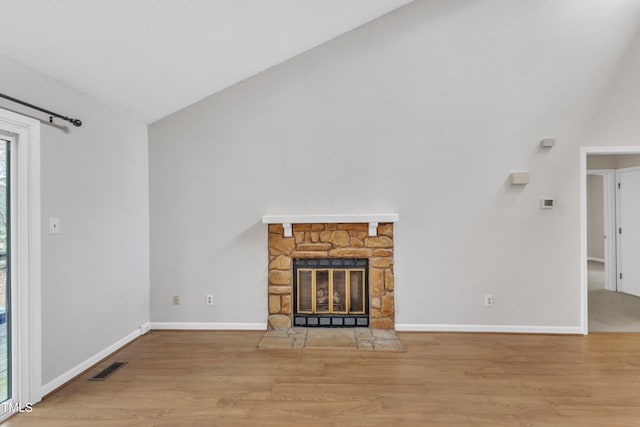 unfurnished living room featuring wood finished floors, a fireplace, visible vents, and baseboards