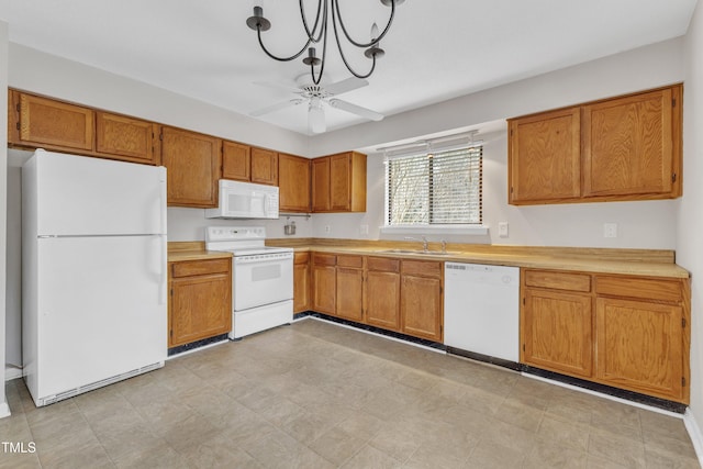 kitchen with a sink, white appliances, brown cabinetry, and light countertops