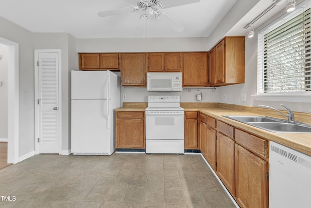 kitchen featuring brown cabinets, a sink, white appliances, light countertops, and ceiling fan