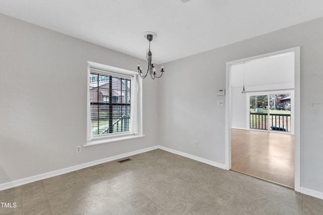 empty room with tile patterned floors, a notable chandelier, baseboards, and visible vents