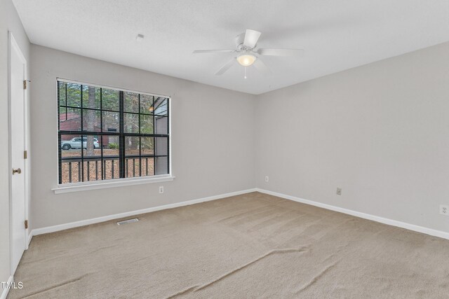 unfurnished room with visible vents, baseboards, ceiling fan, and carpet flooring