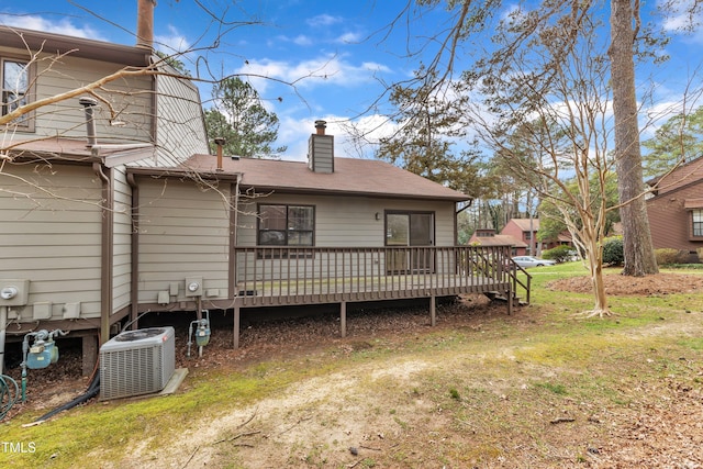 back of house featuring central air condition unit, a wooden deck, and a chimney