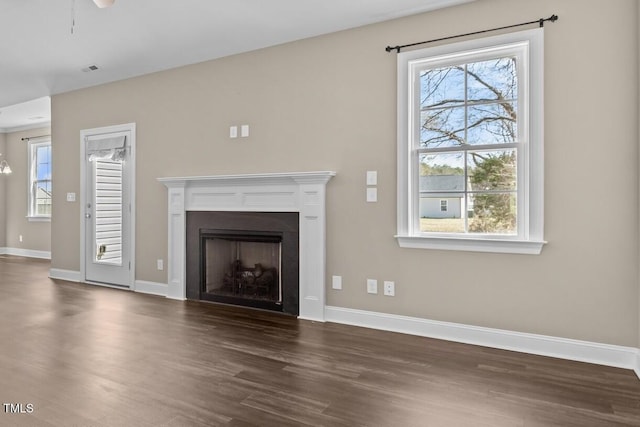 unfurnished living room with dark wood finished floors, visible vents, a fireplace, and baseboards