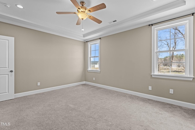 carpeted spare room featuring crown molding, a ceiling fan, baseboards, and visible vents