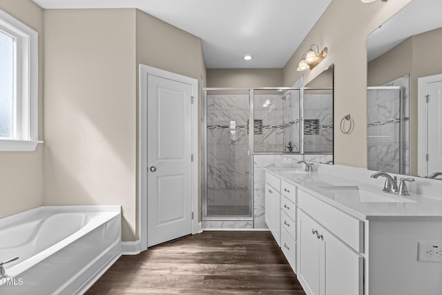 full bath featuring a sink, wood finished floors, and a shower stall