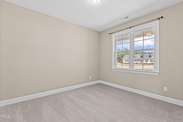 carpeted empty room featuring visible vents and baseboards