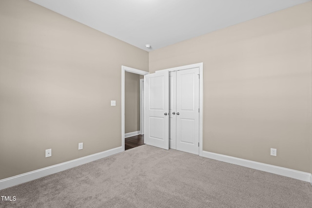 unfurnished bedroom featuring a closet, baseboards, and carpet