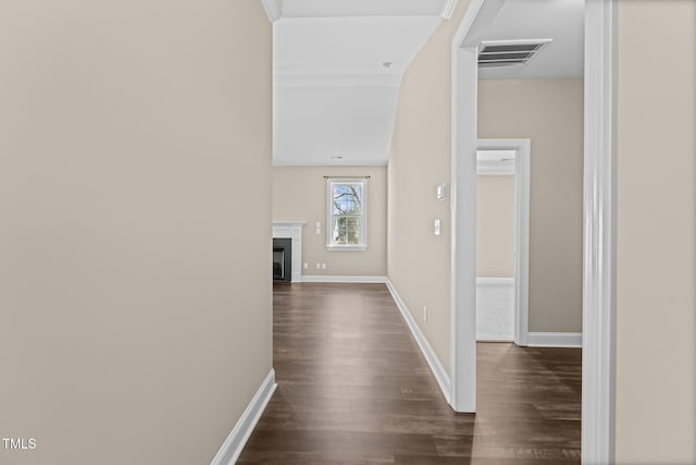 corridor with visible vents, dark wood-type flooring, and baseboards