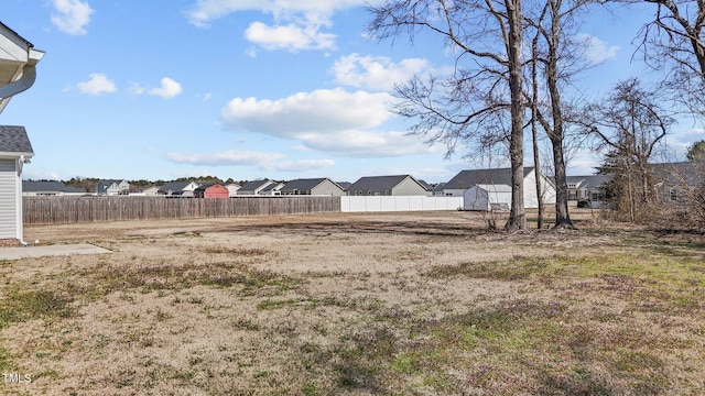 view of yard featuring fence and a residential view