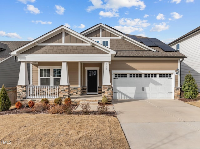 craftsman-style house with stone siding, a porch, board and batten siding, concrete driveway, and a garage