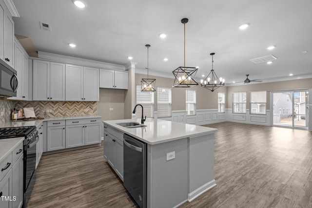 kitchen featuring decorative backsplash, black appliances, visible vents, and a sink