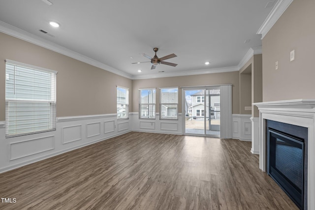 unfurnished living room featuring a glass covered fireplace, wood finished floors, and a healthy amount of sunlight