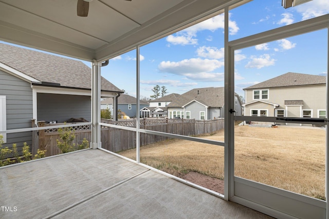 sunroom with a residential view and ceiling fan