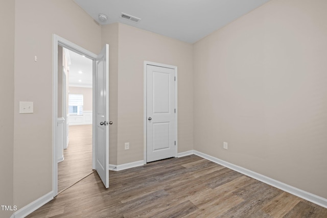 unfurnished bedroom with visible vents, baseboards, and wood finished floors