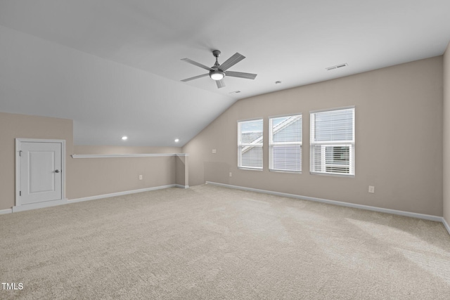 additional living space featuring visible vents, a ceiling fan, carpet floors, baseboards, and vaulted ceiling