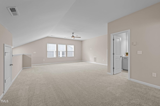 unfurnished living room featuring light carpet, visible vents, and lofted ceiling