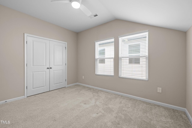 unfurnished bedroom featuring vaulted ceiling, carpet flooring, visible vents, and a closet