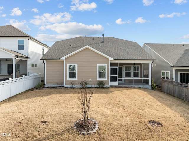 back of house featuring a fenced backyard, a sunroom, and a shingled roof