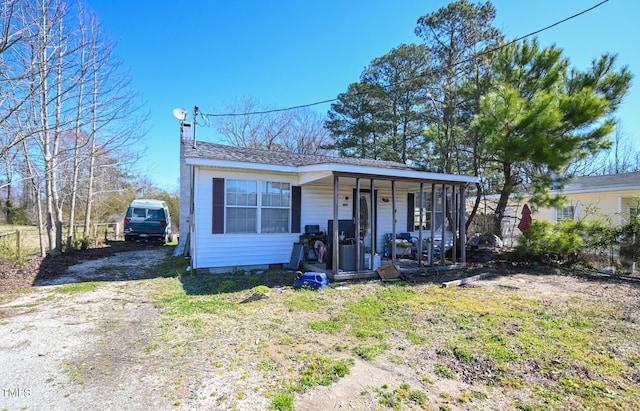 view of front of house featuring crawl space, a porch, and driveway