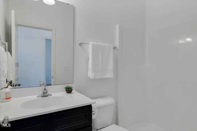 bathroom with toilet, vanity, and walk in shower