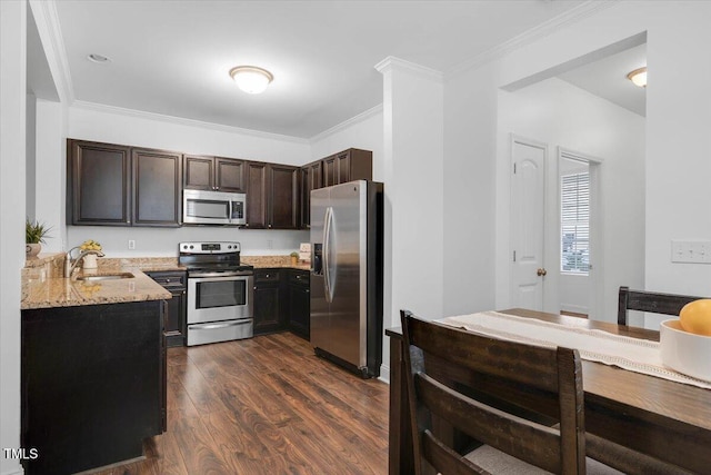 kitchen featuring ornamental molding, a sink, light stone counters, dark wood-style floors, and stainless steel appliances