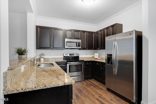 kitchen with light stone counters, ornamental molding, stainless steel appliances, and a sink