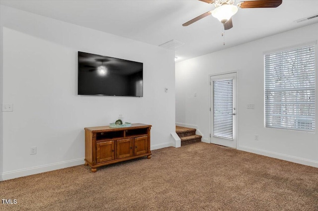 living room featuring baseboards, light colored carpet, visible vents, and ceiling fan