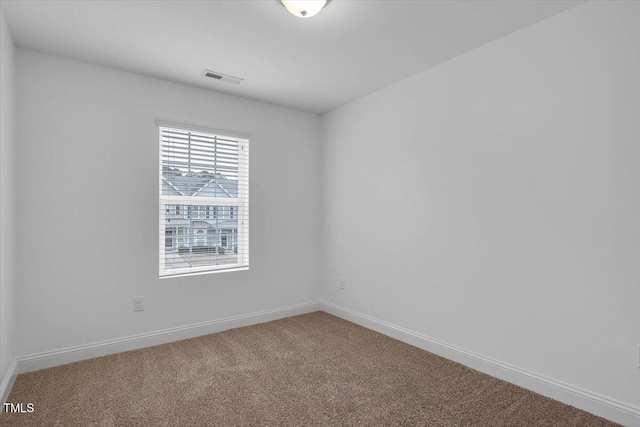 spare room featuring visible vents, carpet floors, and baseboards