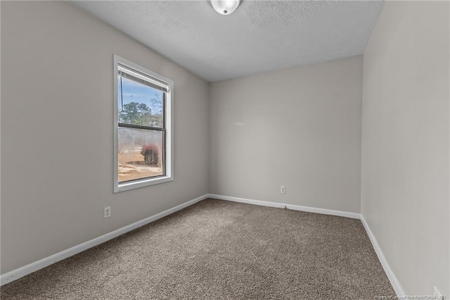 carpeted empty room with a textured ceiling and baseboards