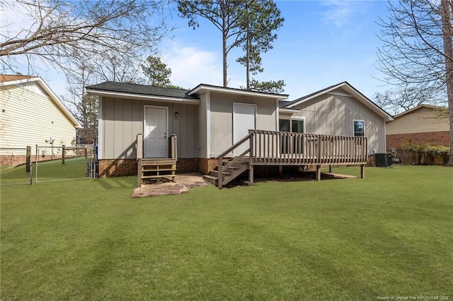 rear view of property with a yard, fence, entry steps, and a gate