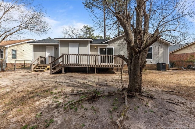 view of front of house with central air condition unit, a shingled roof, a deck, and fence