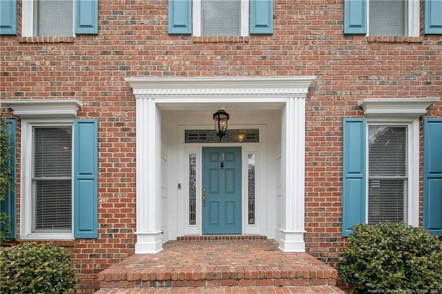 view of exterior entry with brick siding