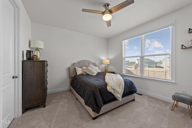 bedroom featuring visible vents, light colored carpet, a ceiling fan, and baseboards