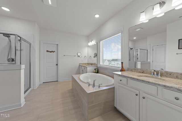 bathroom featuring two vanities, a sink, a shower stall, tile patterned flooring, and a bath