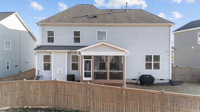 rear view of property featuring crawl space, a fenced backyard, roof with shingles, and a sunroom