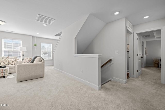 interior space with baseboards, visible vents, an upstairs landing, and carpet floors