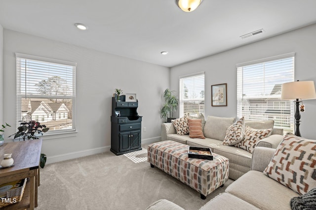 living area with recessed lighting, visible vents, light carpet, and baseboards