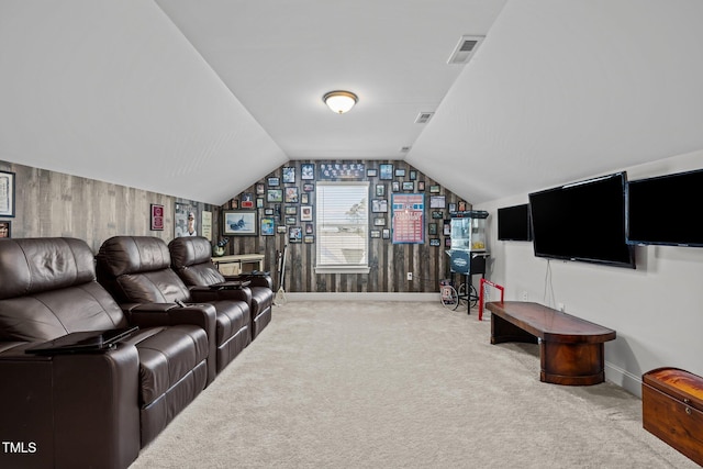 carpeted home theater featuring visible vents, baseboards, wooden walls, and vaulted ceiling