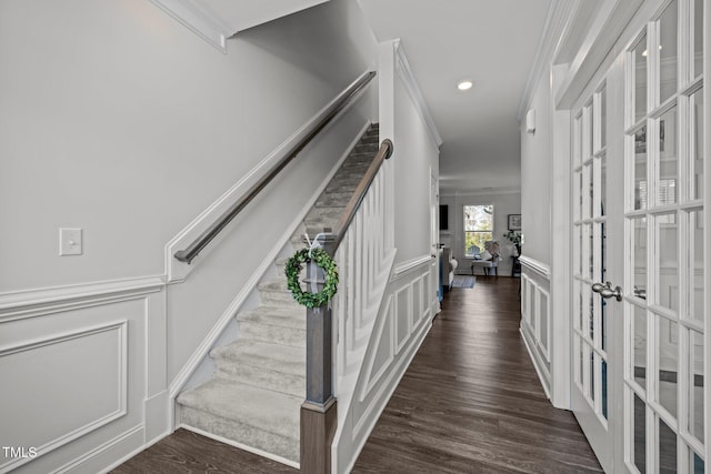 interior space with french doors, wood finished floors, ornamental molding, and a decorative wall