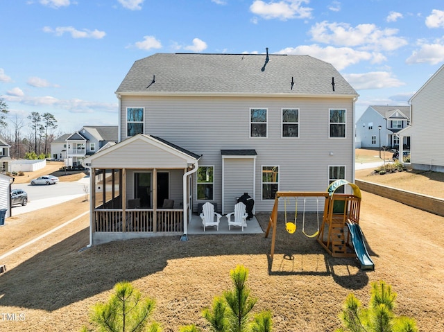 back of house featuring a patio area, a residential view, a playground, and a sunroom