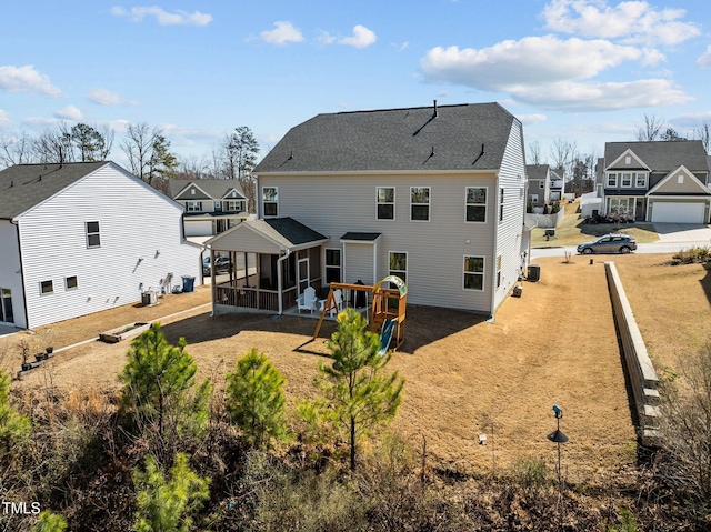 back of property with a residential view, central air condition unit, and a sunroom